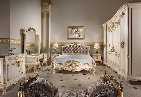 A supreme Italian 19th Century Louis XV style hand carved, patinated off white color and parcel gilded seven pieces grandiose Bedroom Set, exceptionally carved with stunning scrolling movements of acanthus, shells, cartouches, swagging garlands and pierced foliage works; comprising of one tufted upholstered bed, one six doors armoire, one dressing table with mirror, one banquette, one chiffonier and two nightstands.
