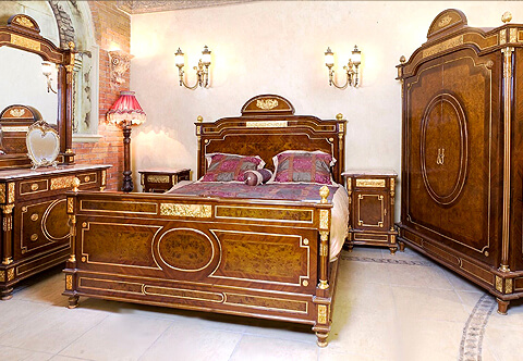 A ritzy French Louis XVI Neoclassical style ormolu-mounted and double veneer inlaid hand crafted Master Bedroom Set, representing the typical Louis XVI Neoclassicism period; constructed of solid walnut wood as all our products with domed shape crests and ornamented with Corinthian style ormolu capitals, ormolu rosettes, trims, chandelles in the flutes, ormolu acorn finials and ormolu beaded bands; the royal set is comprising of one bed, one armoire, one dressing chest and two nightstands.