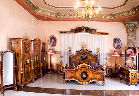Our elaborate prestigious reproduction of the Spanish ormolu-mounted veneer, marquetry inlaid and ebonized Rocaille Royal Bedroom set after the bedroom model of Queen Isabella II of Spain circa 1830 - 1904, the extraordinary bedroom set is made of solid walnut wood and lavishly ormolu embellished with rocaille encadrements, scallops, scrolling acanthus, ormolu flower bouquets, ormolu festoons, ormolu swaging garlands and stunning extensive marquetry patterns; the set is ebonized in harmony and hand painted with foliate designs and comprising of one bed, one armoire, one vanity with mirror, one chair, one curtain cornice and two bedside tables. The original Bedroom is exhibited in the Royal Palace of Aranjuez, Madrid in the town of Aranjuez, the bedroom was the wedding gift the queen received from the city of Barcelona and was used firstly by King Charles IV during the 18th century as his private office but later in the 19th century, it became a bedroom. The bedroom was made by Juan Bautista de Toledo the famous Spanish architect