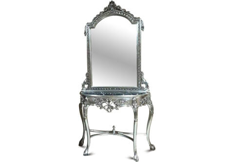 A fine Tiffany French silvered Rococo Louis xv style grand console with mirror, hand carved and silvered with French silver foils and applied with black patina, the domed top mirror crested with a seashell issuing blossoming garlands to the sides terminating with a pine cone pendants on a hammered background frame terminating with an acanthus c-scroll works resting on a D shaped black veined marble top. The D shape apron is ornamented with foliate and blossoming motifs and pierced center forming flowering ribbons. The cabriole splayed S shape legs are headed with foliate motifs terminating with claw and ball feet which is carved to represent a bird's claw grasping a ball derived from the Chinese dragon's claw holding a crystal ball or jewel and joined by a curvy sectional hammered X stretcher centered with a coned urn